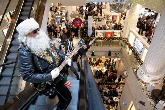 rock Santa plays a guitar on an escalator