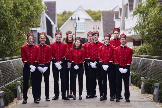 Bellboys in red jackets pose together