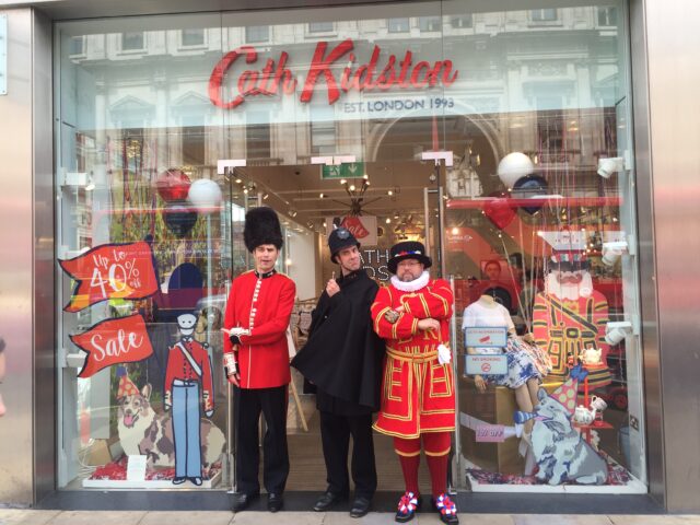 Beefeaters and policemen in front of a store