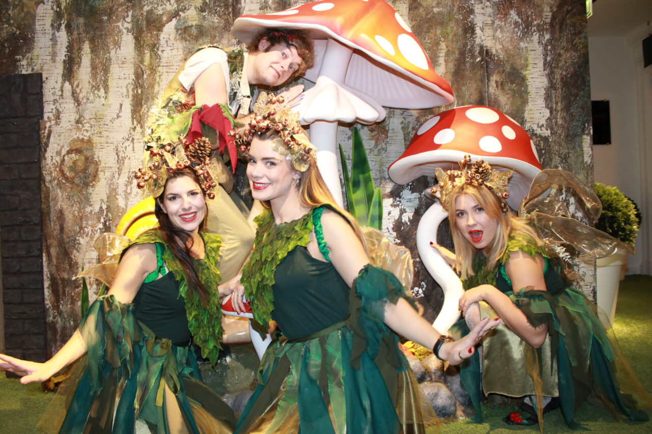 Woodland elves pose together in front of the entrance to the grotto