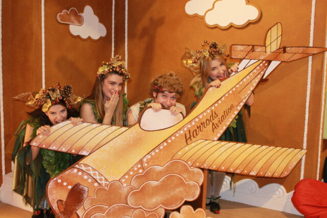 Woodland elves pose around a model of a aeroplane