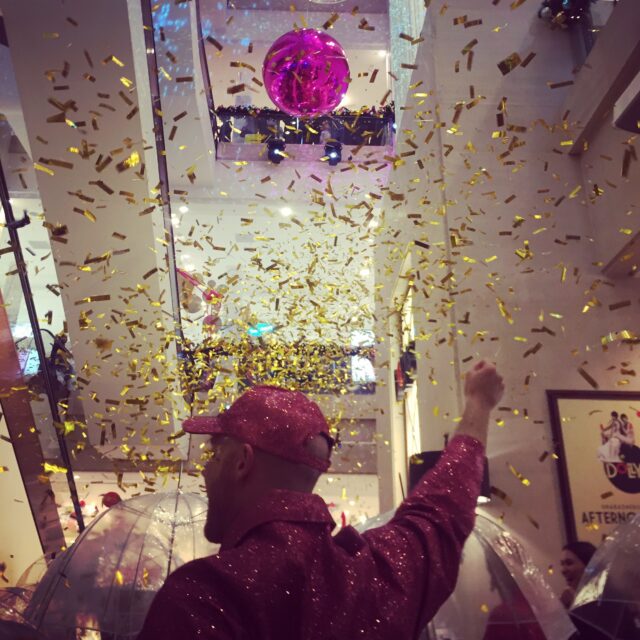 A man travels up an escalator in confetti