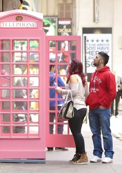 Two people look at the temptation telephone box